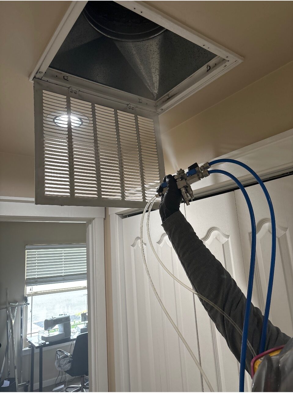 A North State Pure Maintenance technician applying VaPURE treatment through an HVAC vent